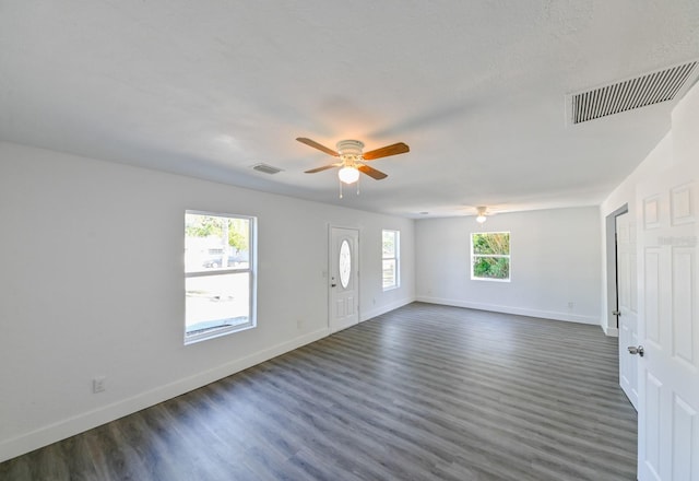 interior space featuring a wealth of natural light, dark wood-type flooring, and ceiling fan