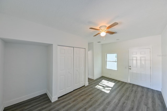 unfurnished bedroom featuring ceiling fan, dark hardwood / wood-style flooring, and a closet