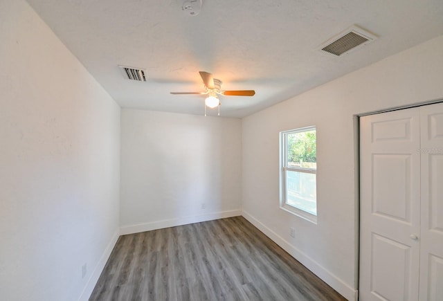 empty room with hardwood / wood-style flooring and ceiling fan