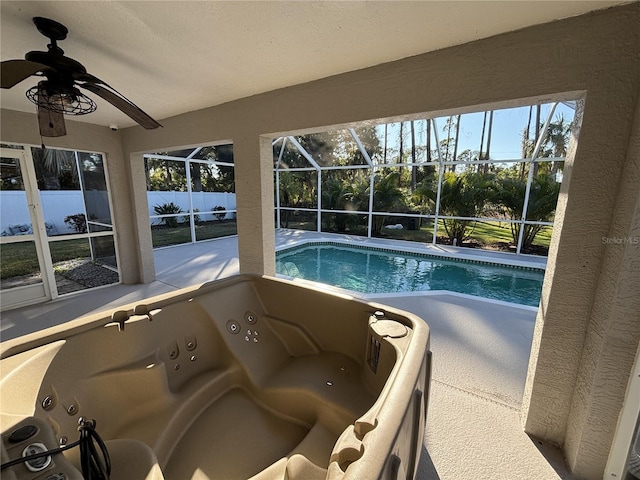 view of pool with a jacuzzi, a patio, ceiling fan, and a lanai