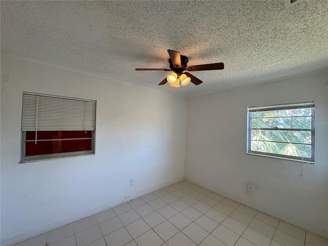 tiled spare room featuring a textured ceiling and ceiling fan