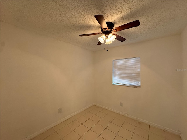 tiled spare room with ceiling fan and a textured ceiling