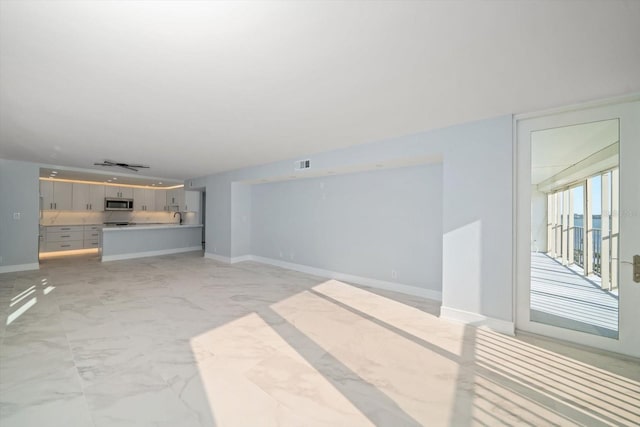 unfurnished living room featuring sink