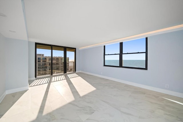 empty room featuring a water view and expansive windows