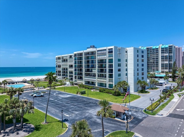 view of apartment building / complex with a water view and uncovered parking