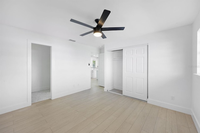 unfurnished bedroom featuring a closet, light hardwood / wood-style flooring, and ceiling fan