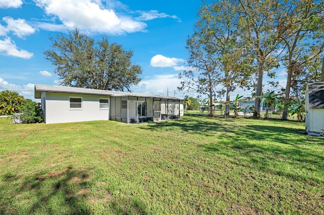 rear view of house featuring a lawn and a sunroom