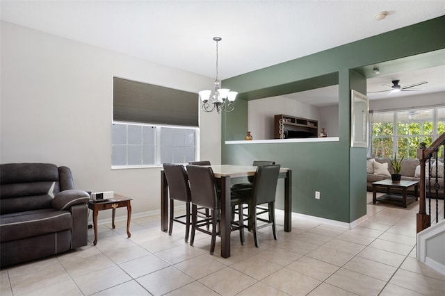 dining room featuring ceiling fan with notable chandelier and light tile patterned flooring