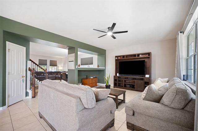 living room with ceiling fan, light tile patterned flooring, and a wealth of natural light