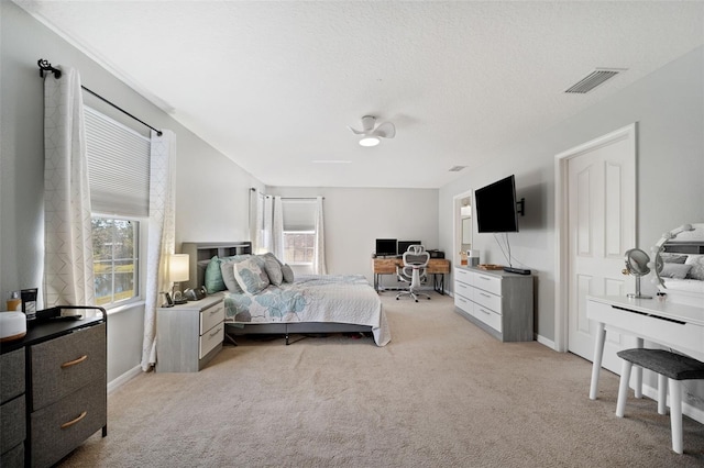 carpeted bedroom featuring ceiling fan and a textured ceiling