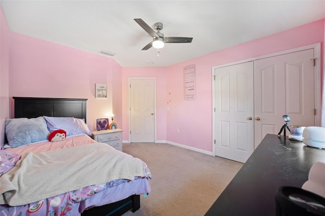 bedroom with ceiling fan, light carpet, and a closet