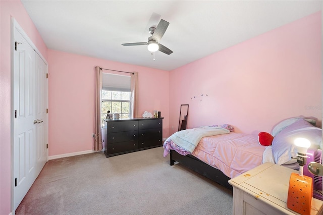 carpeted bedroom featuring a closet and ceiling fan