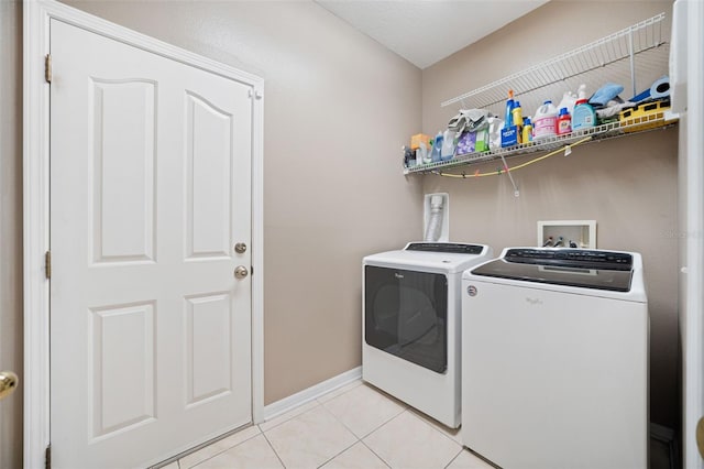 laundry area featuring light tile patterned floors and separate washer and dryer