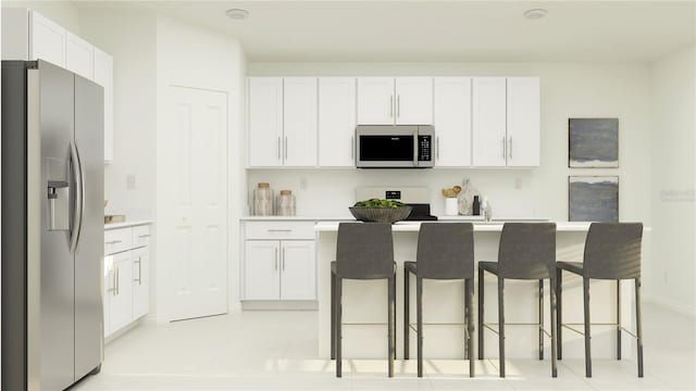 kitchen featuring a kitchen island with sink, white cabinetry, and stainless steel appliances