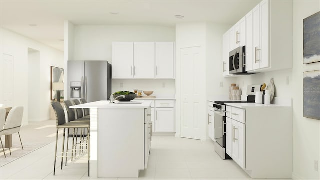 kitchen featuring white cabinets, a kitchen bar, stainless steel appliances, and a kitchen island