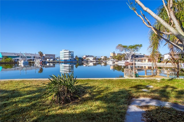 view of dock with a yard and a water view