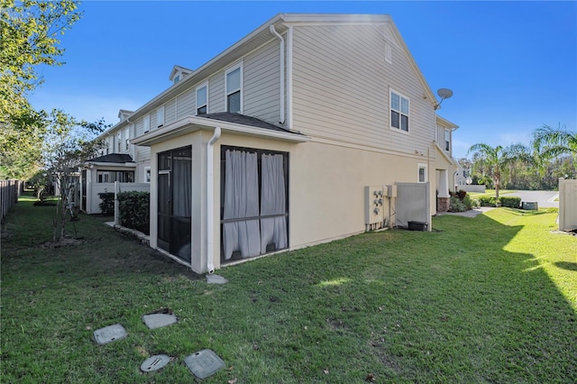 back of property featuring a yard and a sunroom