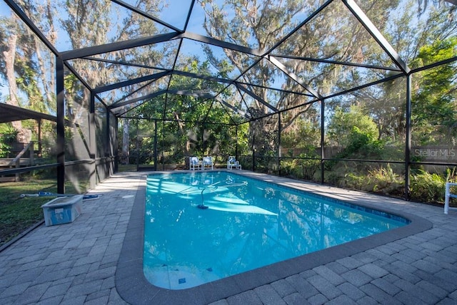 view of pool with a patio area and a lanai