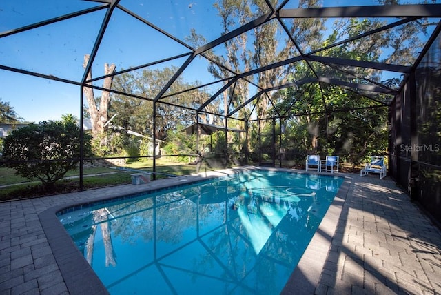 view of swimming pool with a lanai and a patio