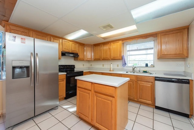 kitchen featuring a kitchen island, light tile patterned flooring, sink, and appliances with stainless steel finishes