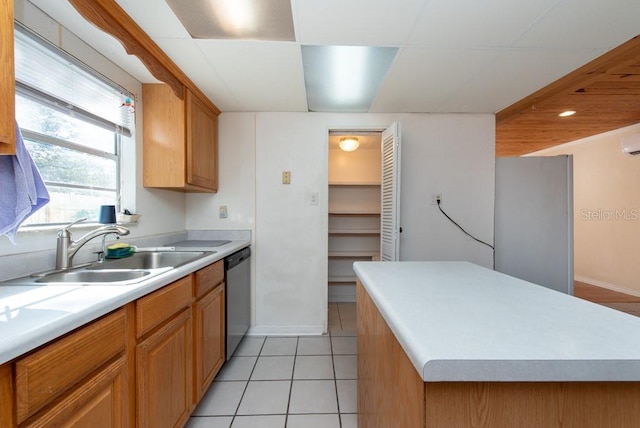 kitchen featuring appliances with stainless steel finishes, light tile patterned floors, a kitchen island, and sink