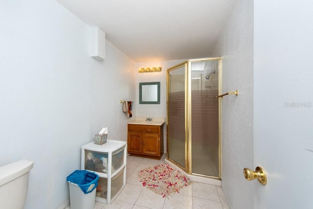 bathroom with tile patterned floors, vanity, toilet, and walk in shower