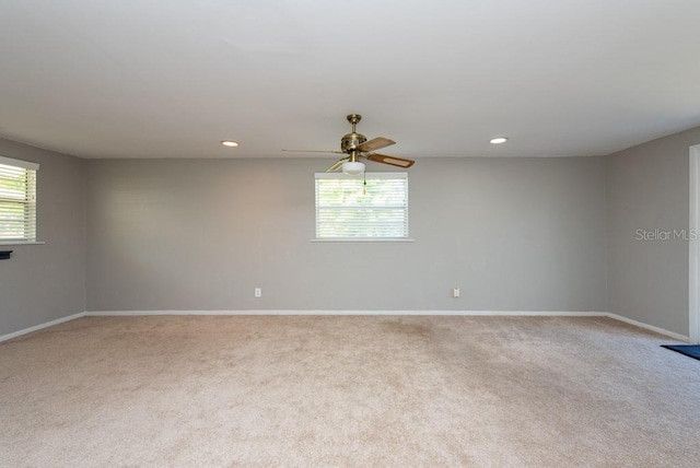 empty room with plenty of natural light, ceiling fan, and light carpet