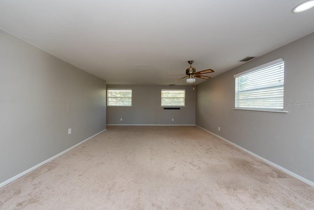 carpeted spare room featuring ceiling fan