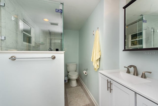 bathroom featuring vanity, toilet, and an enclosed shower