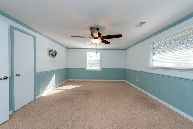 carpeted spare room featuring ceiling fan and crown molding