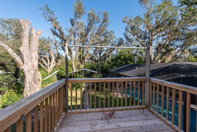 deck featuring a lanai and a swimming pool