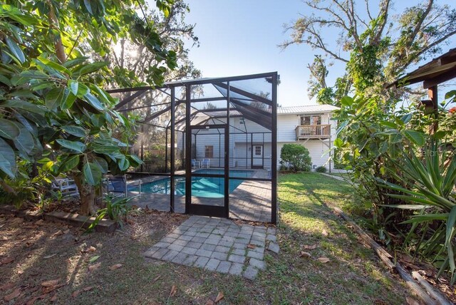 11008 Browning Rd, Lithia, FL 33547 - back of property with an outdoor pool, a patio, a yard, metal roof, and a lanai