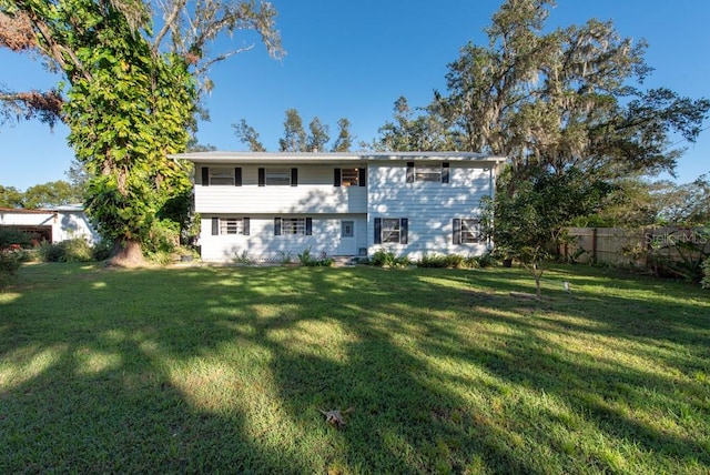 rear view of property featuring a yard