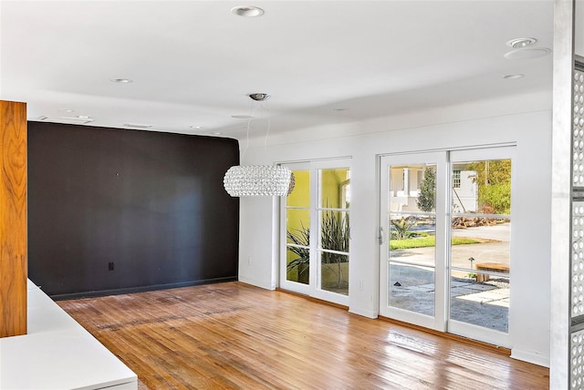 interior space with a notable chandelier and wood-type flooring