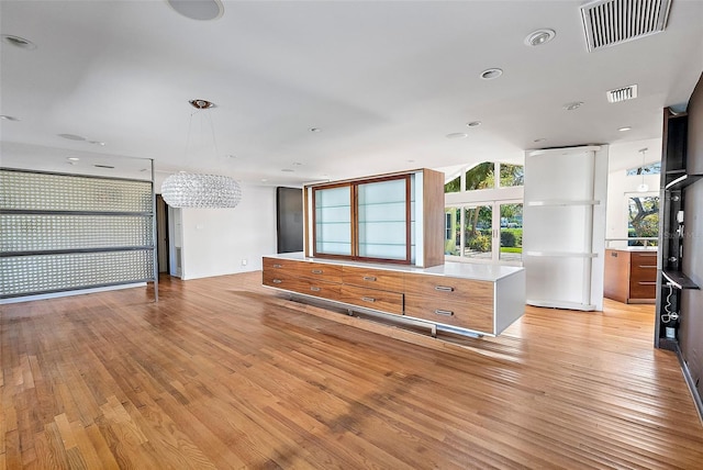 kitchen featuring light hardwood / wood-style flooring, a center island, and a notable chandelier