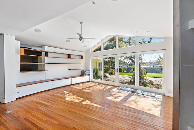 unfurnished living room featuring hardwood / wood-style floors, ceiling fan, vaulted ceiling, and french doors