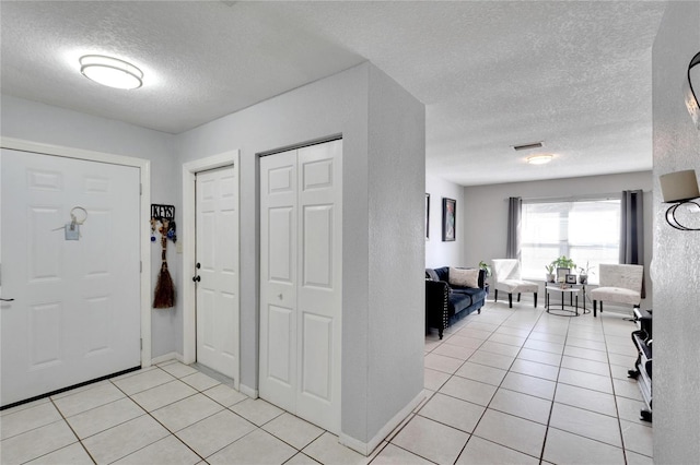 tiled entrance foyer with a textured ceiling