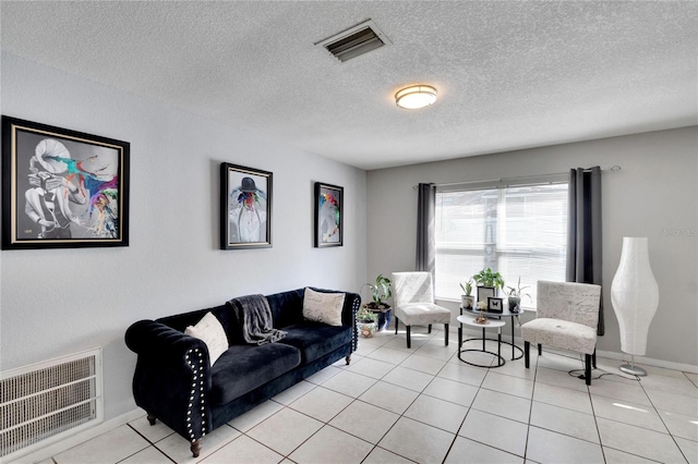 tiled living room featuring a textured ceiling