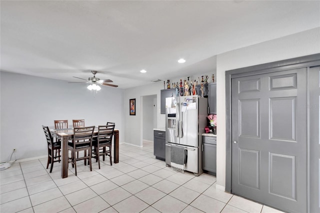 kitchen featuring stainless steel fridge, gray cabinets, ceiling fan, and light tile patterned flooring