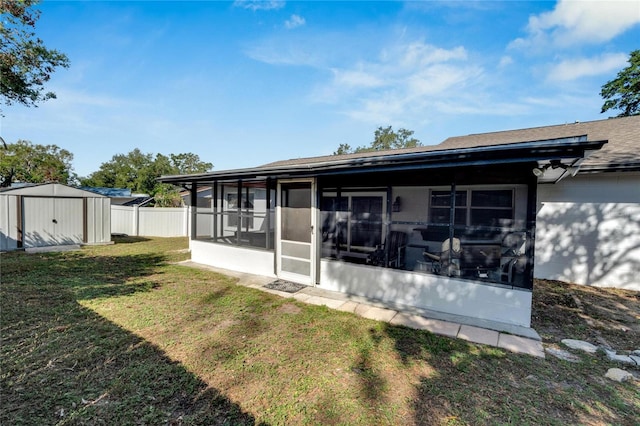 back of property featuring a sunroom, a yard, and a storage shed