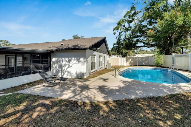 view of pool with a sunroom, central AC unit, a storage shed, and a patio