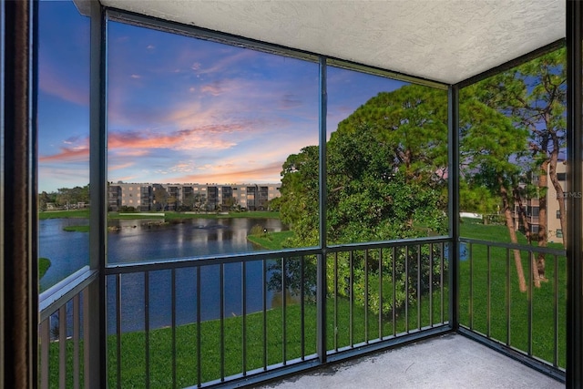 unfurnished sunroom featuring a water view