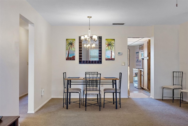 dining area featuring carpet floors and an inviting chandelier