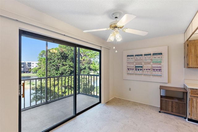 doorway to outside featuring ceiling fan and a textured ceiling