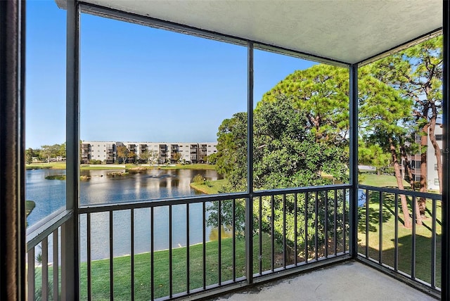 unfurnished sunroom featuring a water view