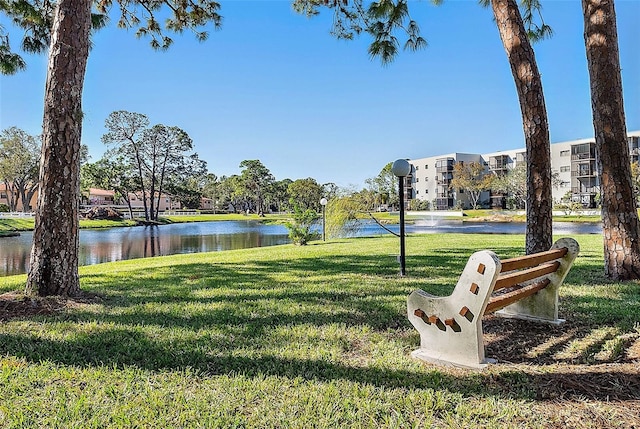 view of home's community with a water view and a yard