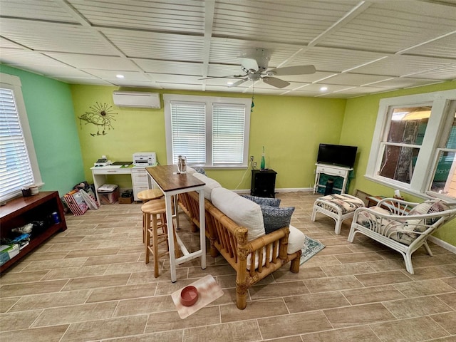 living room with a wall unit AC, ceiling fan, and light wood-type flooring