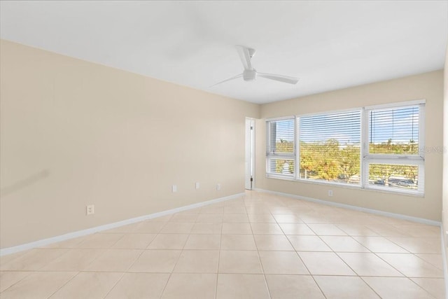 tiled spare room featuring ceiling fan