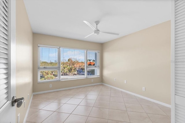 tiled spare room with ceiling fan