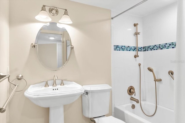 bathroom featuring tiled shower / bath combo and toilet